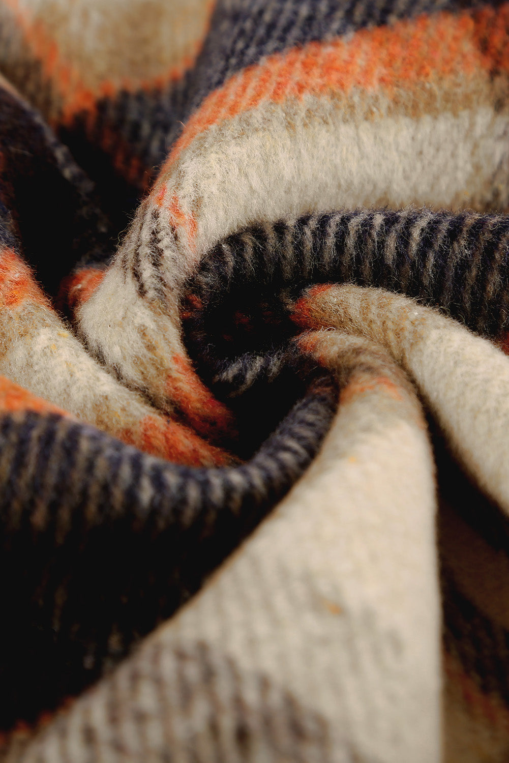 A person wearing a Brown Plaid Button Up Long Sleeve Flannel Shacket layered over a white top with ripped jeans and holding a brown handbag stands against a textured gray wall.