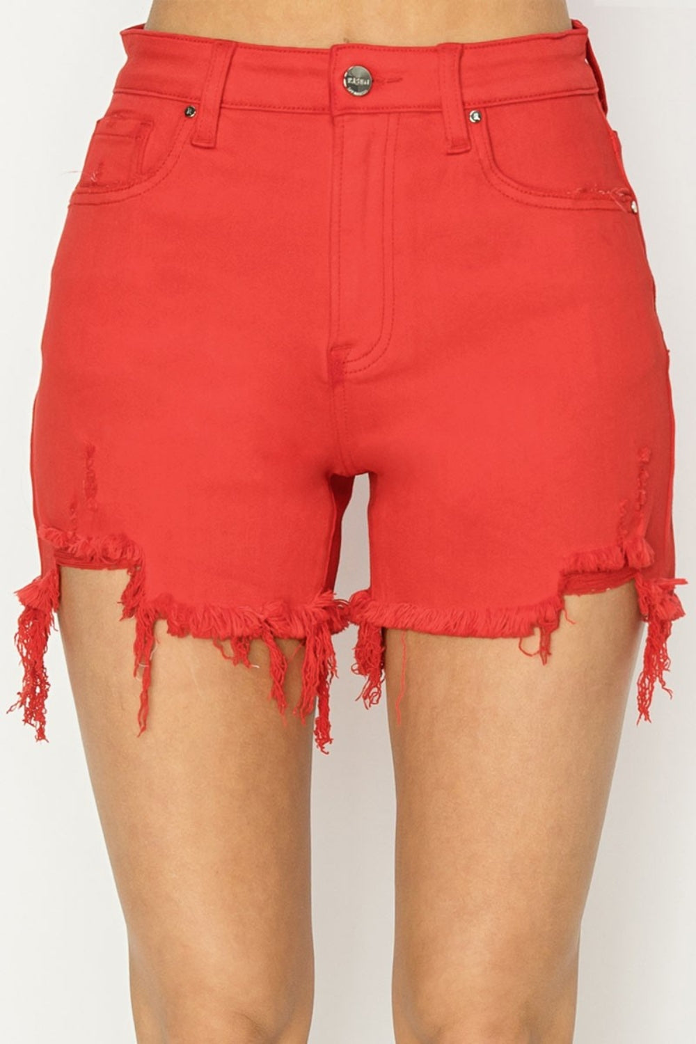 Close-up of a person wearing trendy RISEN High Rise Distressed Denim Shorts with distressed hems and pockets. The versatile wardrobe essential shorts feature a button and zip closure.