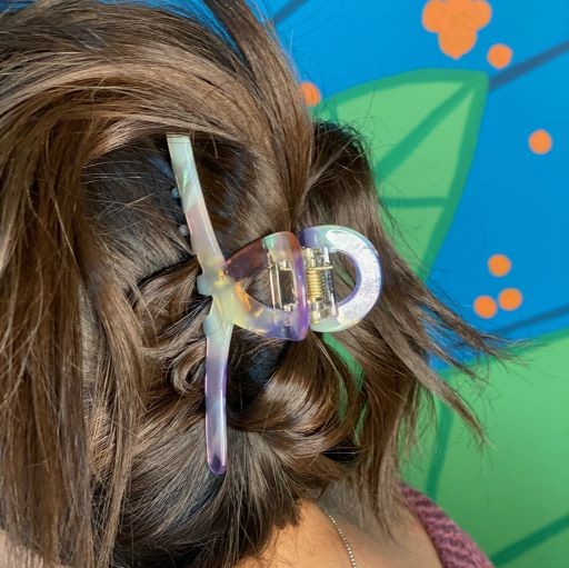 Two different colored Barely There Hair Claws placed on a light-colored surface.