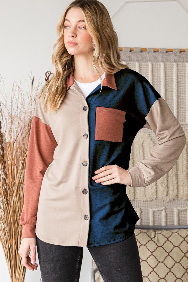 A woman stands indoors wearing the Heimish Full Size Color Block Button Down Shirt, set against a backdrop of a woven tapestry, highlighting her versatile wardrobe.