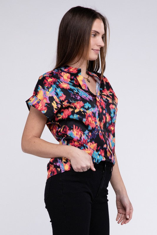 A person stands confidently wearing a colorful, abstract-patterned Notch Neck Top and black pants against a plain background.