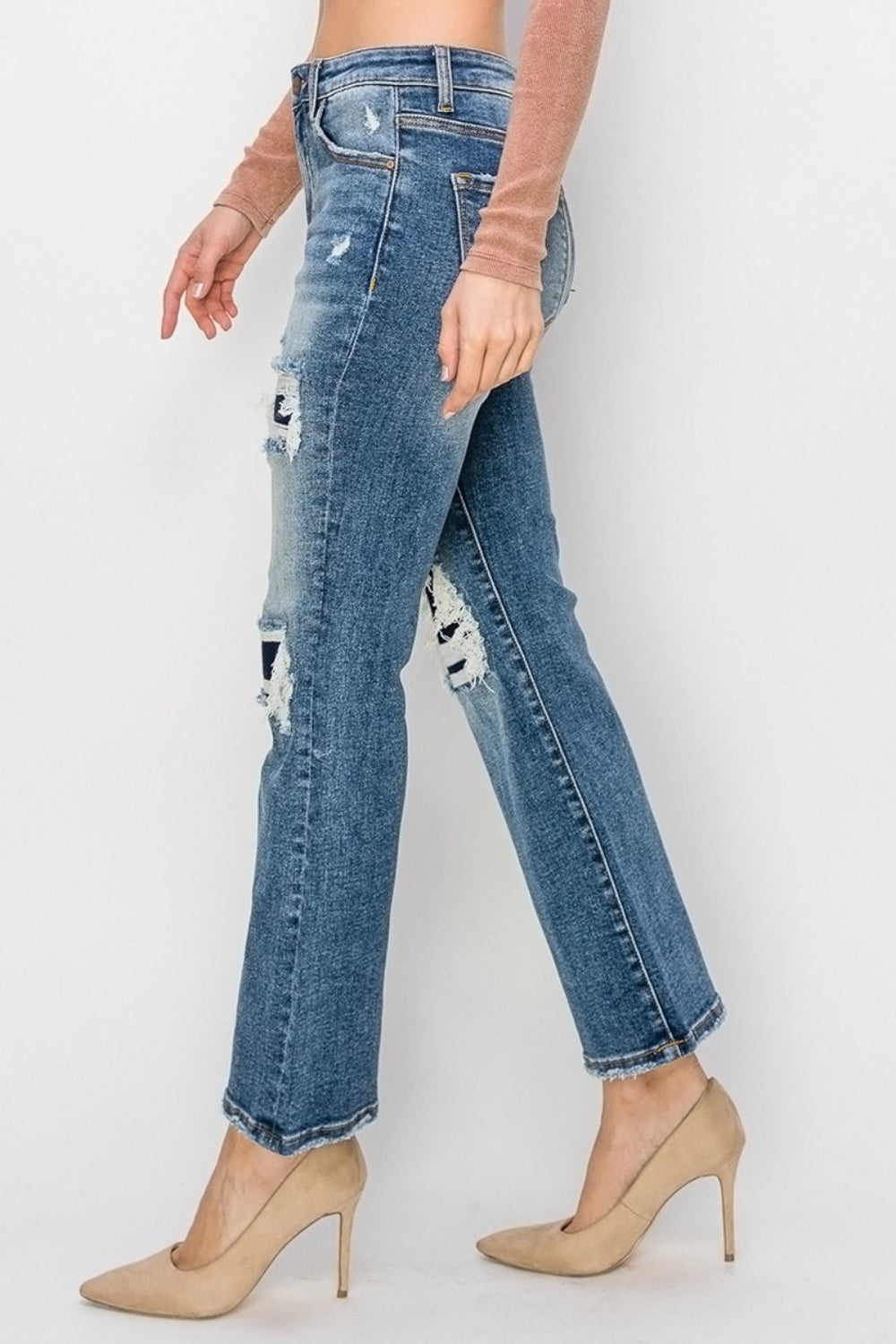 A person showcases their fashion-forward style with Risen Full Size High Rise Distressed Ankle Flare Jeans, paired perfectly with beige heels against a crisp white background.