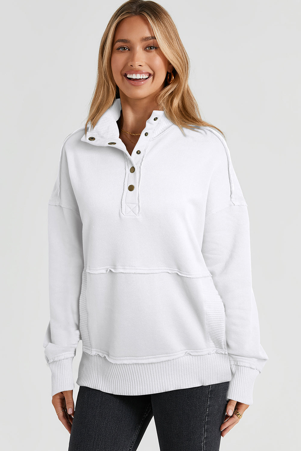 A woman with long hair wearing a White Ribbed Hem Snap Button Neckline Sweatshirt with Pocket is seen from behind, standing against a plain background, embodying a casual look.