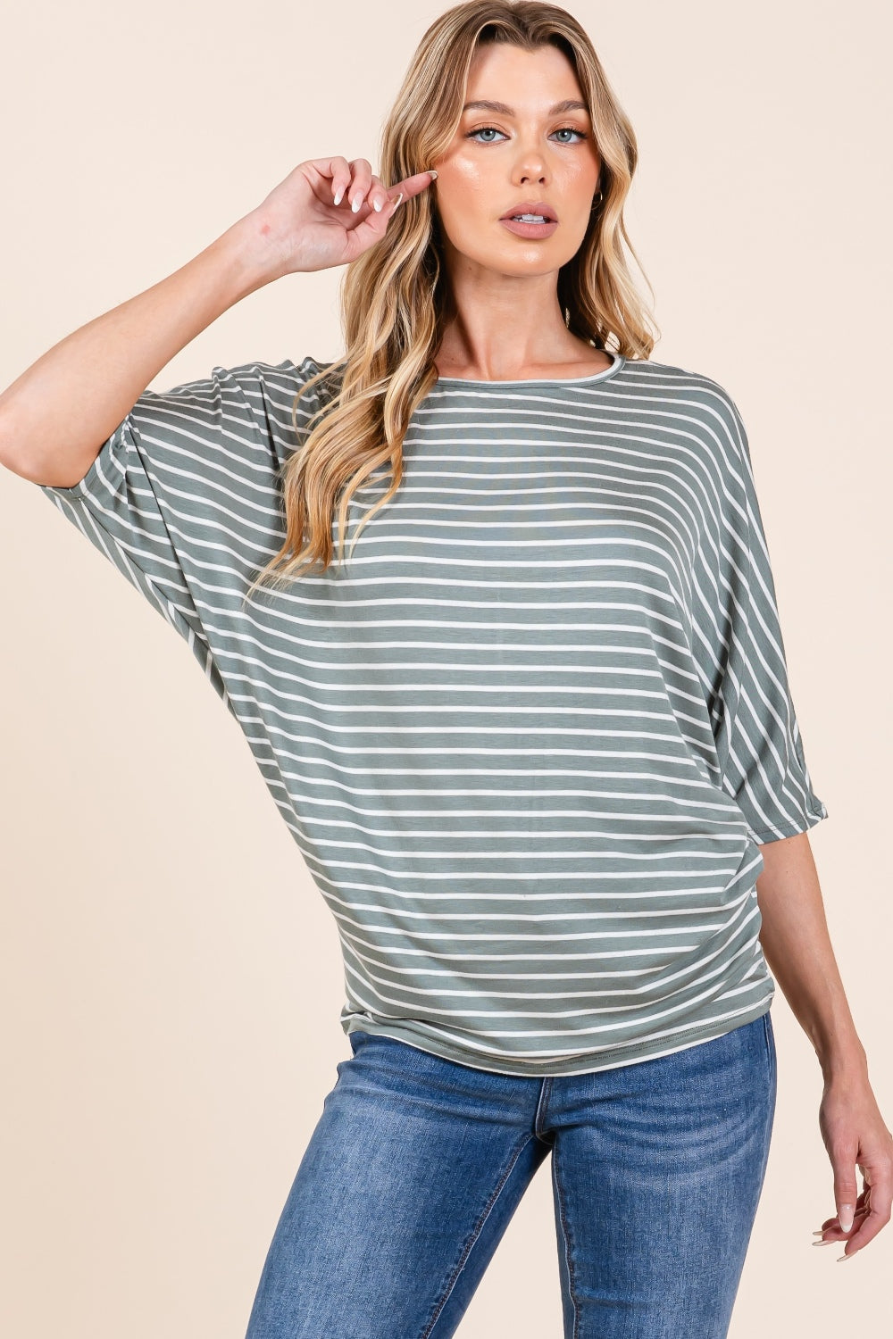 A person with long, wavy hair wearing the BOMBOM Striped Boat Neck Dolman Sleeve Top and blue jeans poses against a plain background.