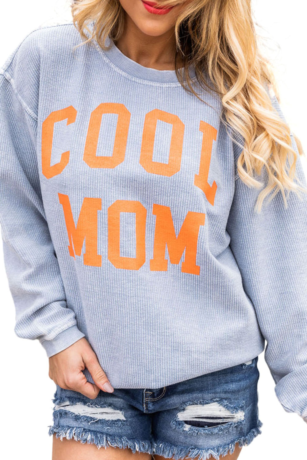 A person with long blonde hair stands facing away, wearing a Gray Cool Mom Graphic Print Cording Sweatshirt and blue jeans.