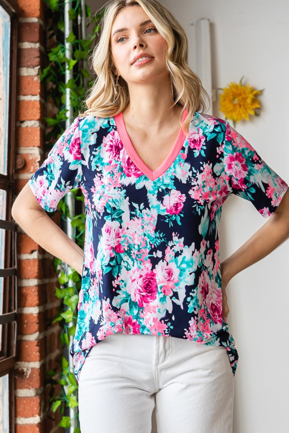 A woman smiling in a colorful Heimish Full Size Floral V-Neck Short Sleeve T-Shirt.