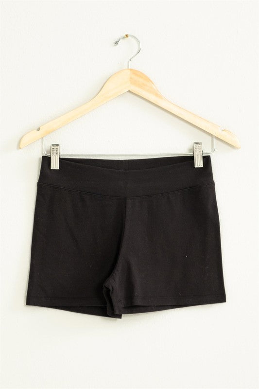 The Take Pride Mid-Rise Biker Shorts, crafted from stretch fabric, hang gracefully on a wooden hanger against a pale wall.