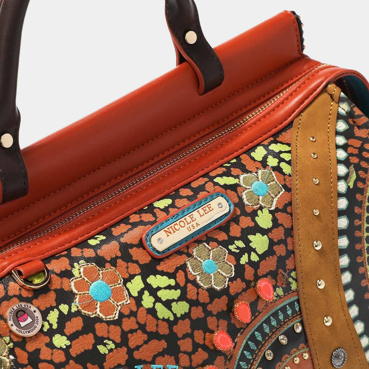 Nicole Lee USA's Front Stitch Detail Inlaid Stud Handbag is a lively vegan leather piece featuring brown handles, a blend of floral and geometric patterns, inlaid studs, and an ornamental charm.