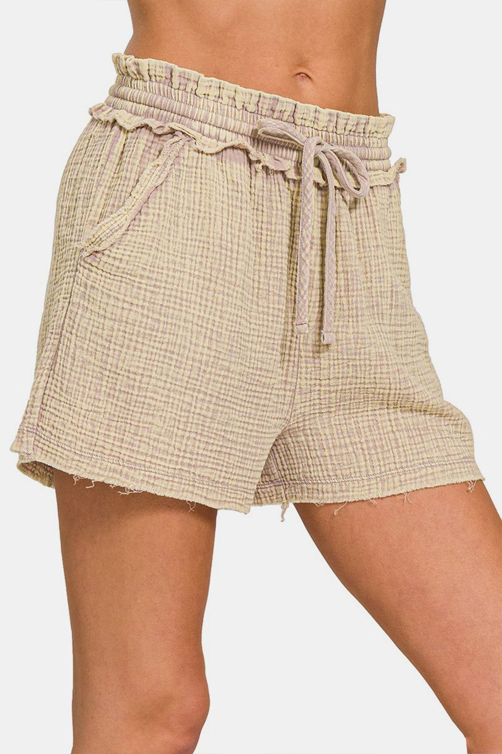 The person is wearing the Zenana Washed Frayed Hem Drawstring Shorts, featuring a light beige hue and textured cotton fabric, ideal for any summer wardrobe.