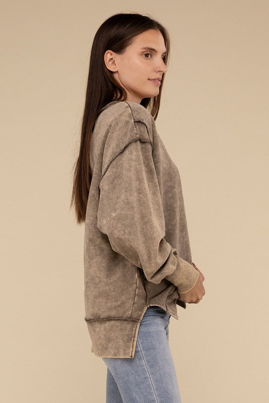 Woman in an Acid Wash French Terry Exposed-Seam sweatshirt standing against a beige background.