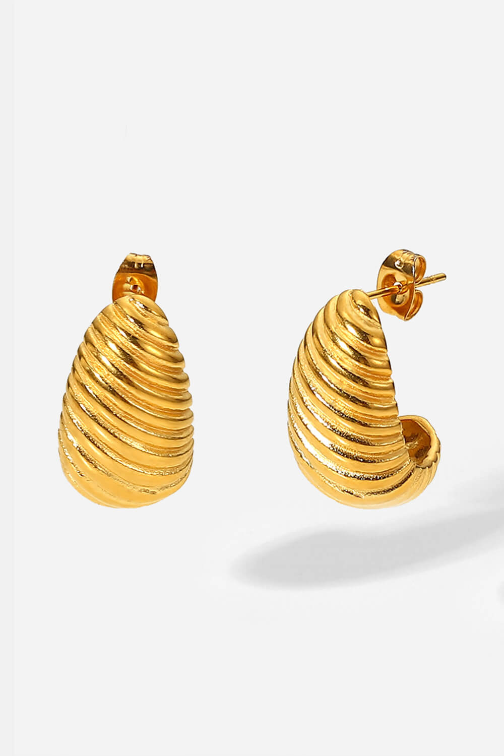 A pair of Shell Shore Spiral Stud Earrings, gold-plated with a ribbed, crescent shape and post-butterfly clasps on a white background.