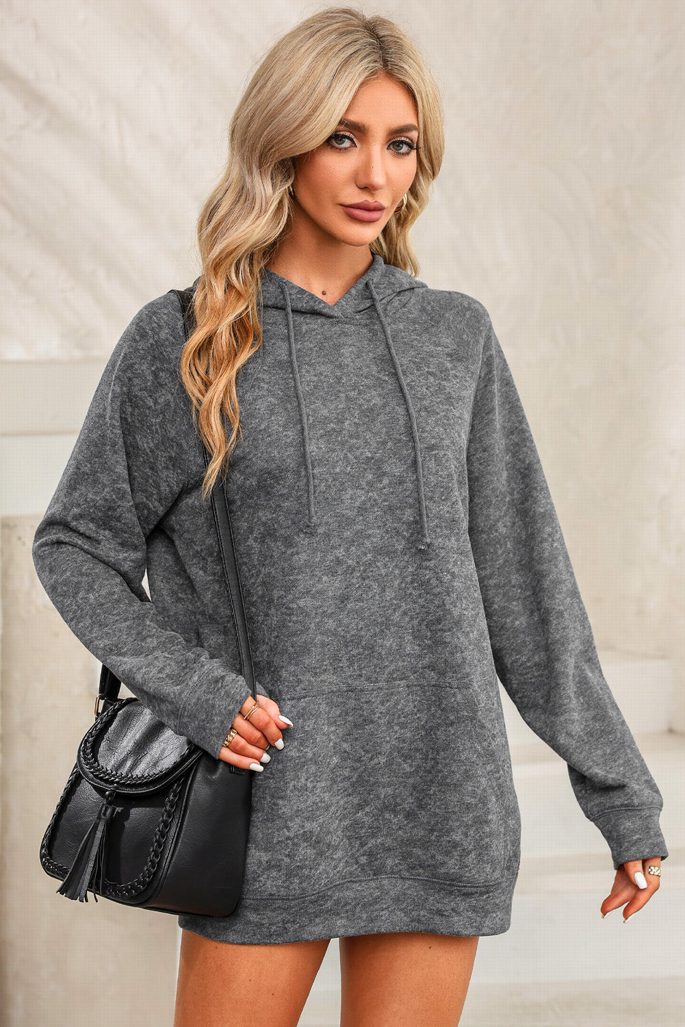 A person with blonde hair is standing with their back to the camera, wearing a Gray Mineral Wash Kangaroo Pocket Drawstring Pullover Hoodie.