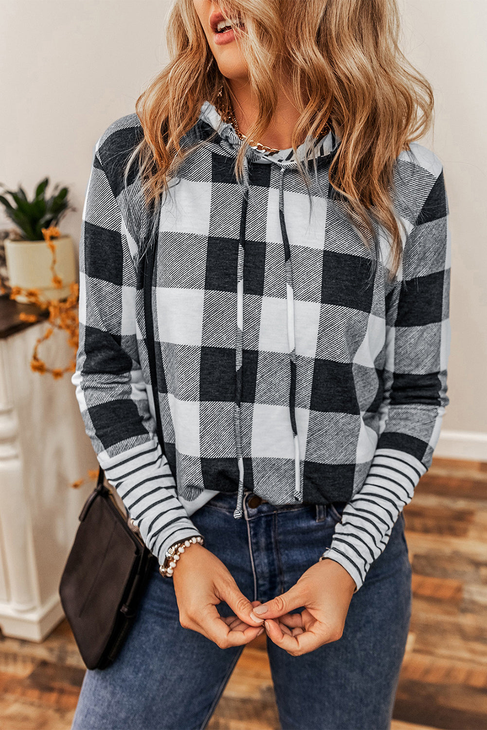 A person with wavy hair wearing a Multicolour Plaid Striped Patchwork Drawstring Hoodie stands indoors, facing away from the camera.