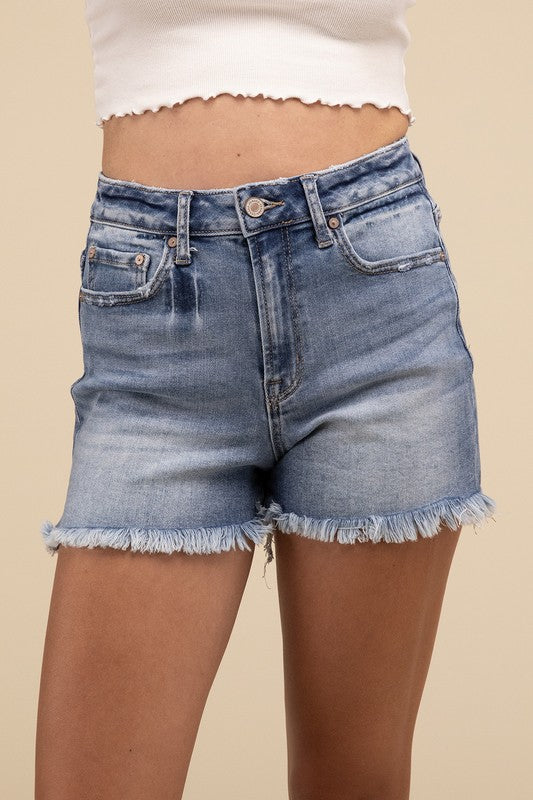 Individual wearing Mid Rise Raw Frayed Hem Denim Shorts paired with a white cropped top.