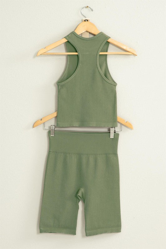 The Power Move Cropped Tank Top and Biker Shorts Set hangs on a wooden hanger against a white background, making it the perfect workout apparel.