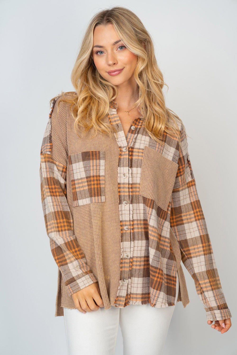 A person with long, blonde hair smiles while wearing the White Birch Full Size Contrast Plaid Button Down Shirt in beige, brown, and white hues, paired with white pants.