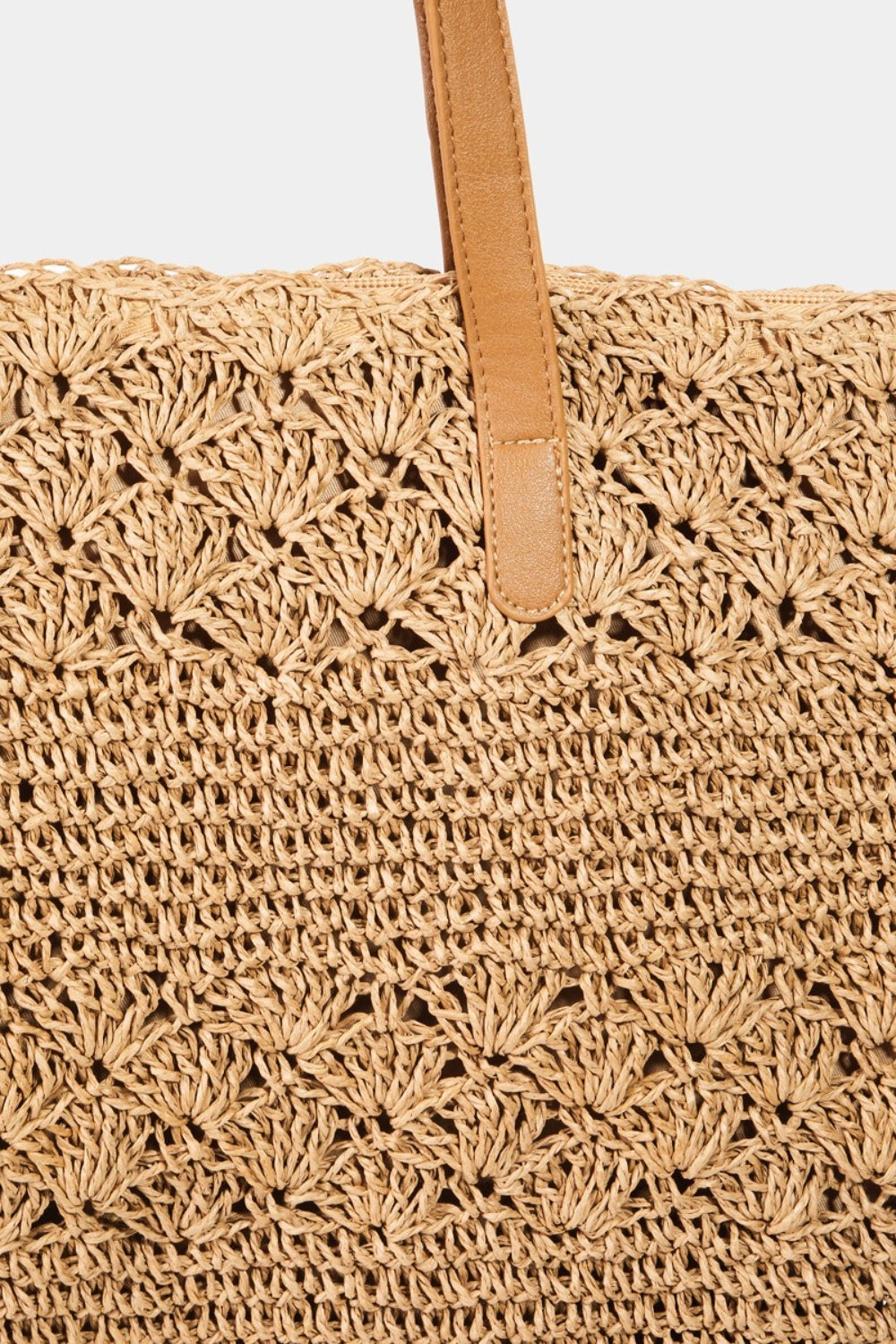 The Fame Straw Braided Tote Bag, featuring beige leather handles and a textured pattern, exudes rustic elegance and is the perfect summery accessory.