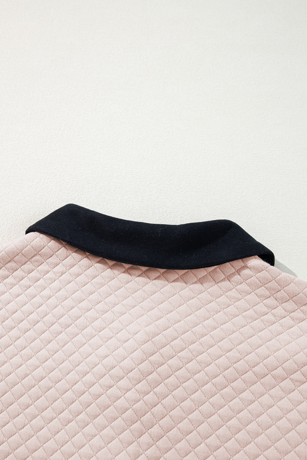 A person wearing an Oatmeal Textured Colorblock Edge Buttoned Collar Sweatshirt, paired with blue jeans, stands with their back to the camera against a white backdrop. The trendy sweatshirt features stylish textured fabric and buttoned collars that add an extra touch of sophistication.