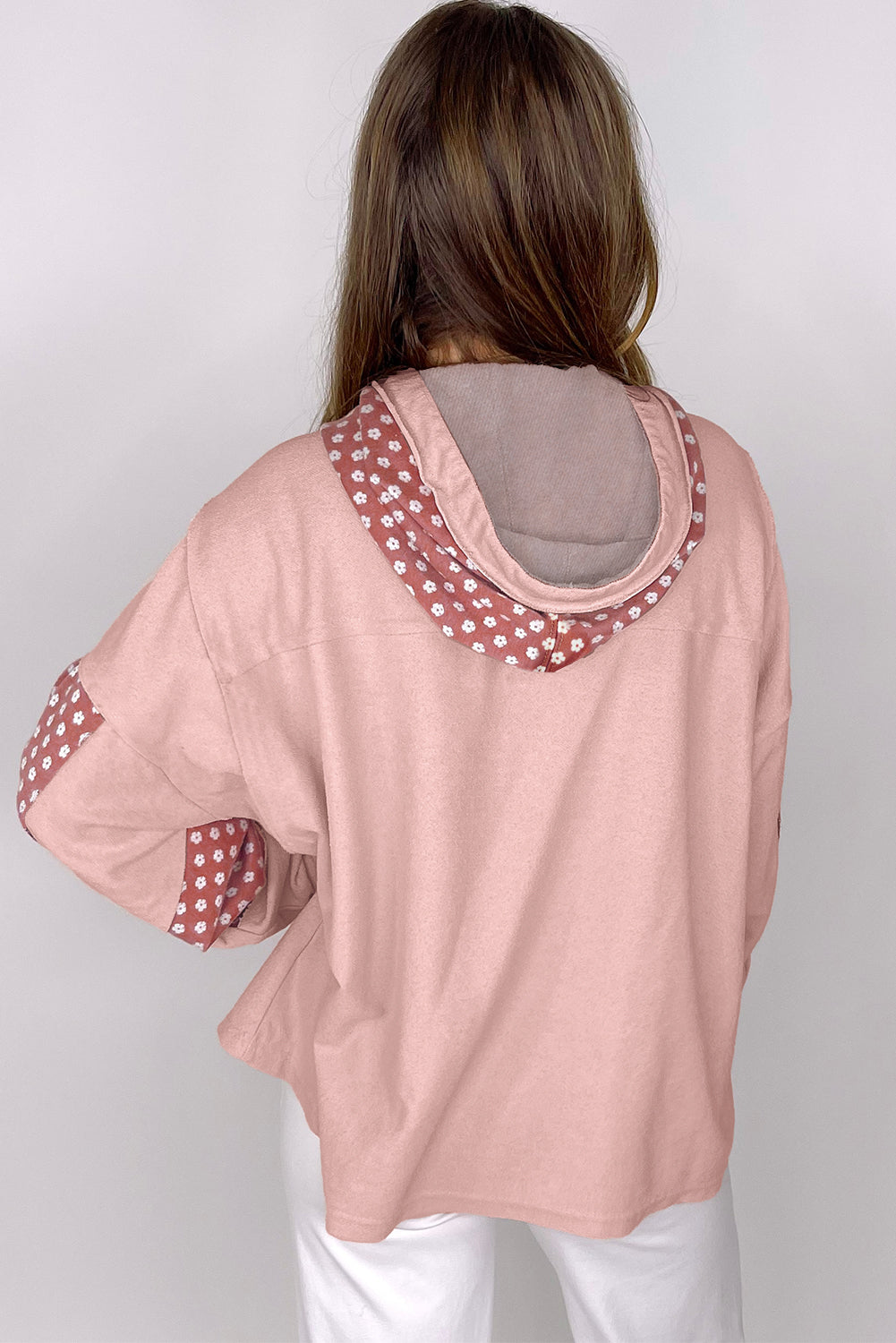 Person wearing the Delicacy Floral Patchwork Star Pattern Drawstring Hoodie, showcasing the floral patchwork design on the hood and sleeves from the back.