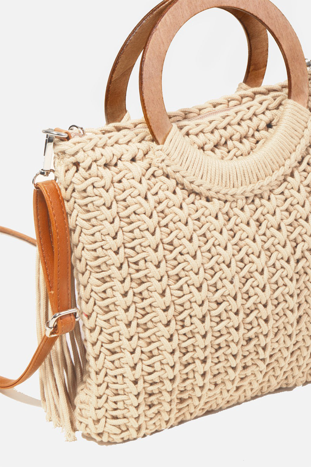 The Fame Crochet Knit Convertible Tote Bag includes a cream-colored design with round wooden handles and a matching tassel accent.