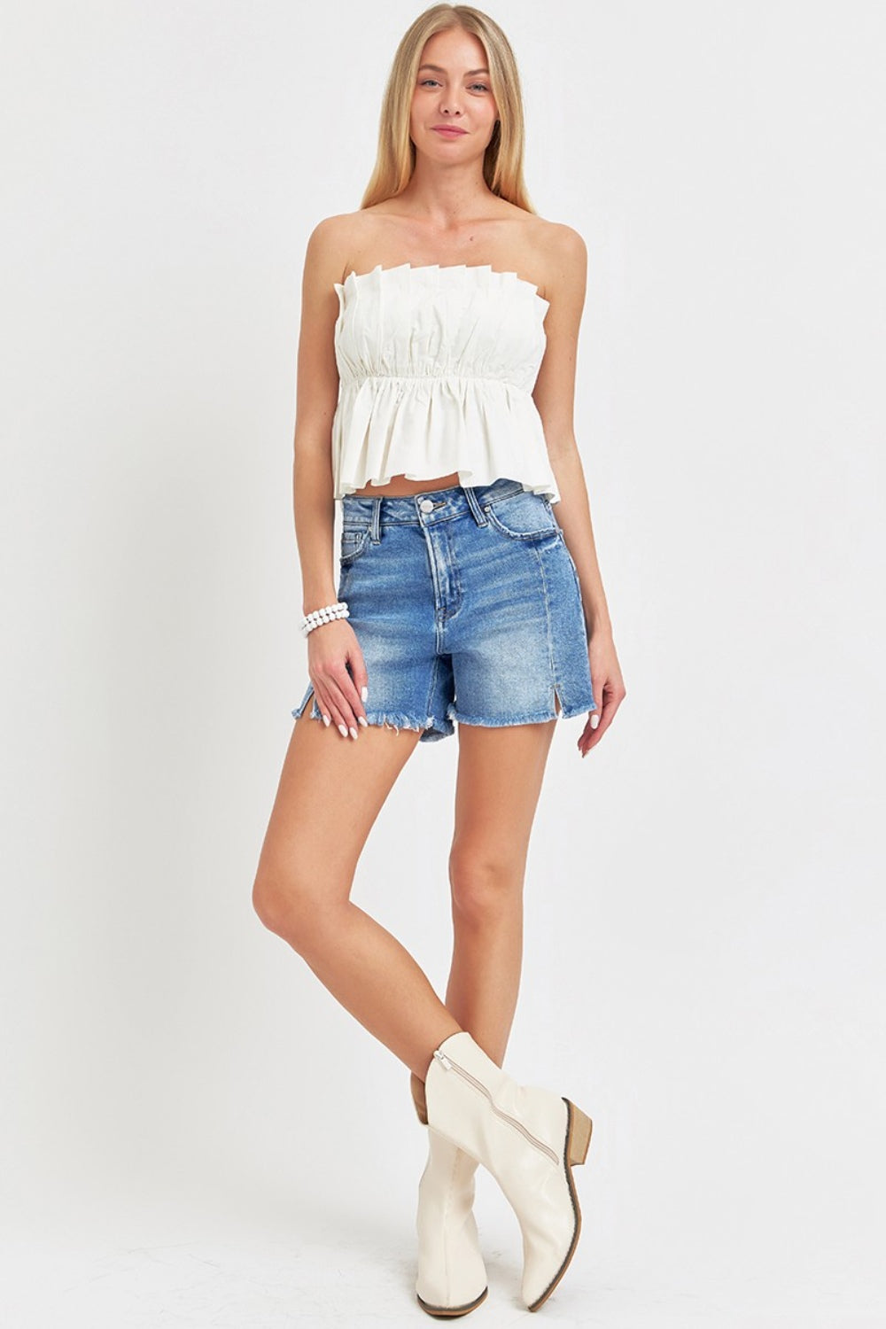 Close-up of a person wearing RISEN Front Slit Raw Hem Denim Shorts.