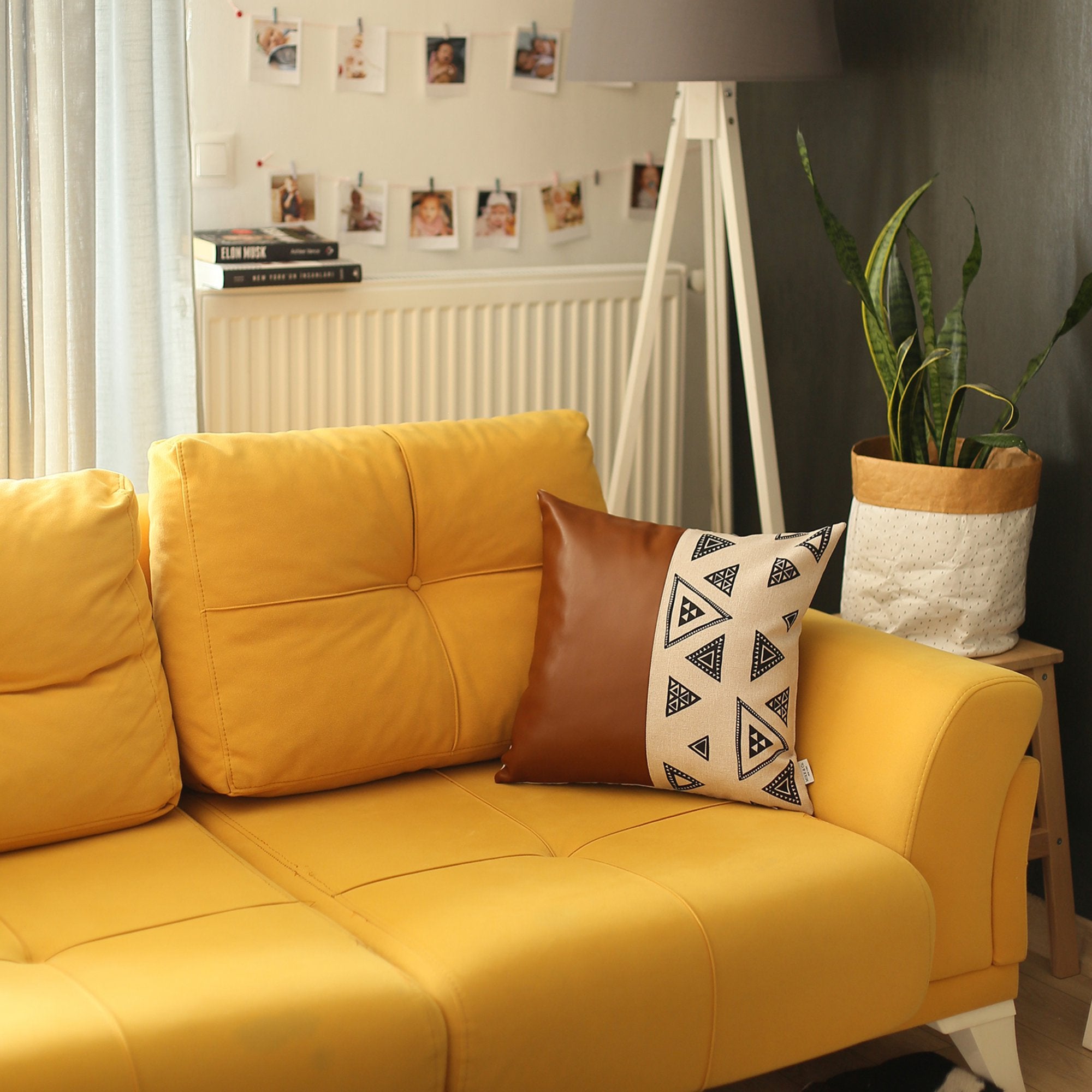 Resting on a yellow cushion is the Bohemian Handmade Decorative Single Throw Pillow, featuring vegan faux leather with a geometric pattern on one half. The setup is completed with round lights draped over it, showcasing the eclectic charm of bohemian throw pillows.