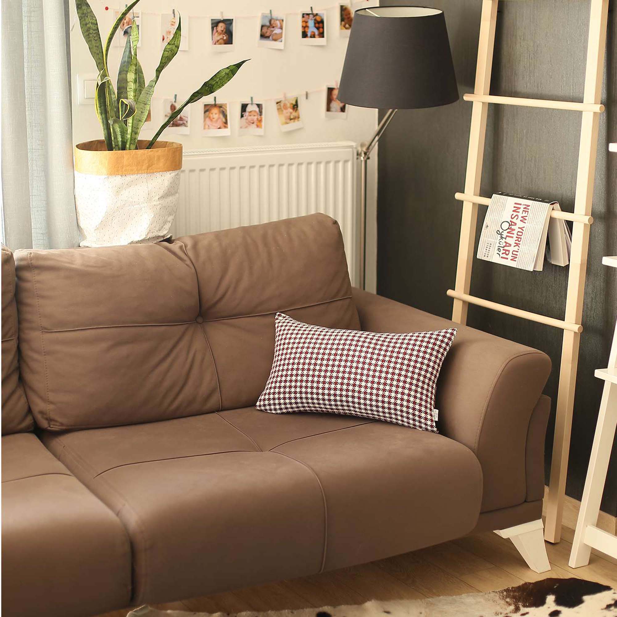 The Bohemian Handmade Decorative Throw Pillow, featuring a houndstooth jacquard design and crafted to OEKO-TEX Standard 100, adds charm to the brown sofa beside a magazine rack.