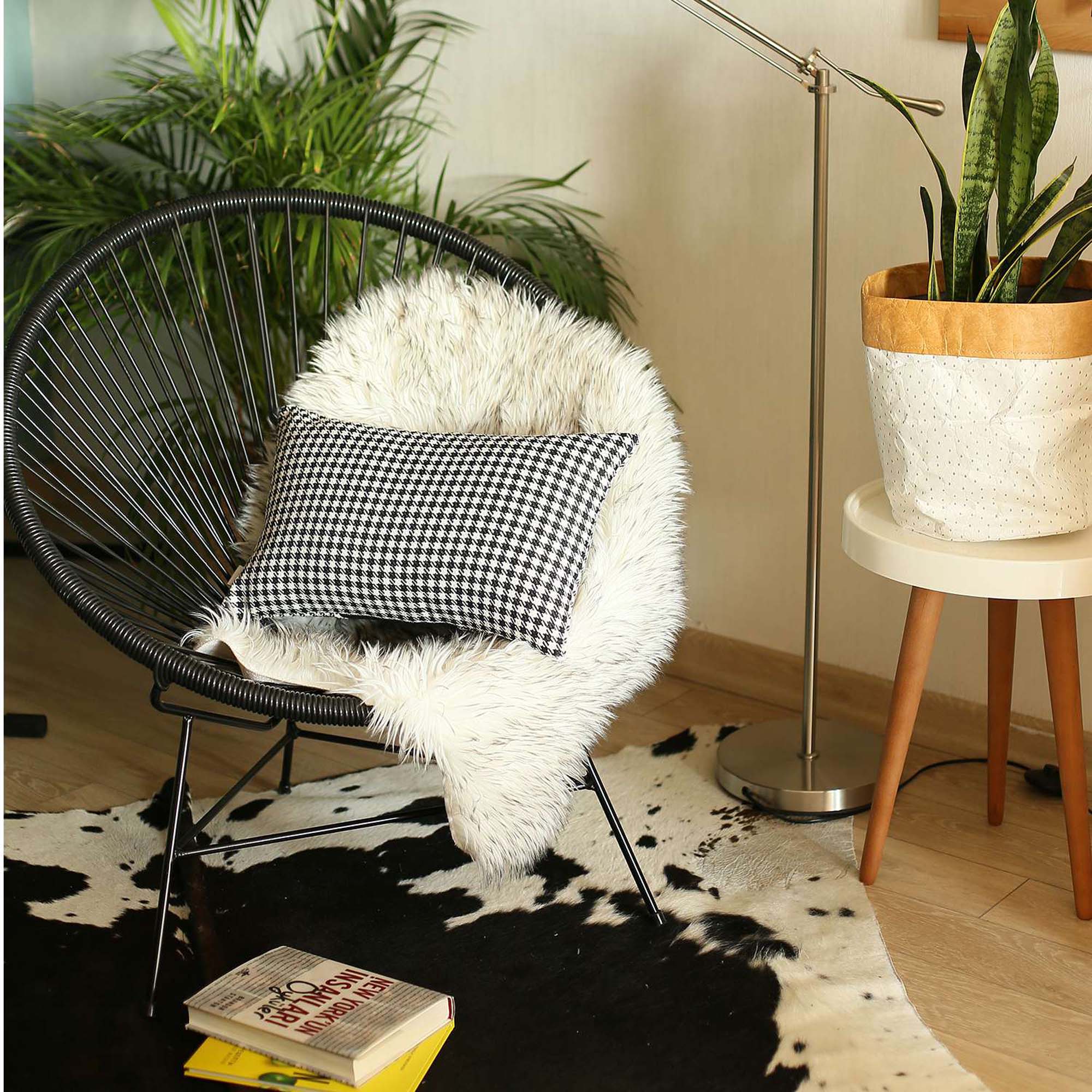 The Bohemian Handmade Decorative Throw Pillow, featuring a houndstooth jacquard design and crafted to OEKO-TEX Standard 100, adds charm to the brown sofa beside a magazine rack.