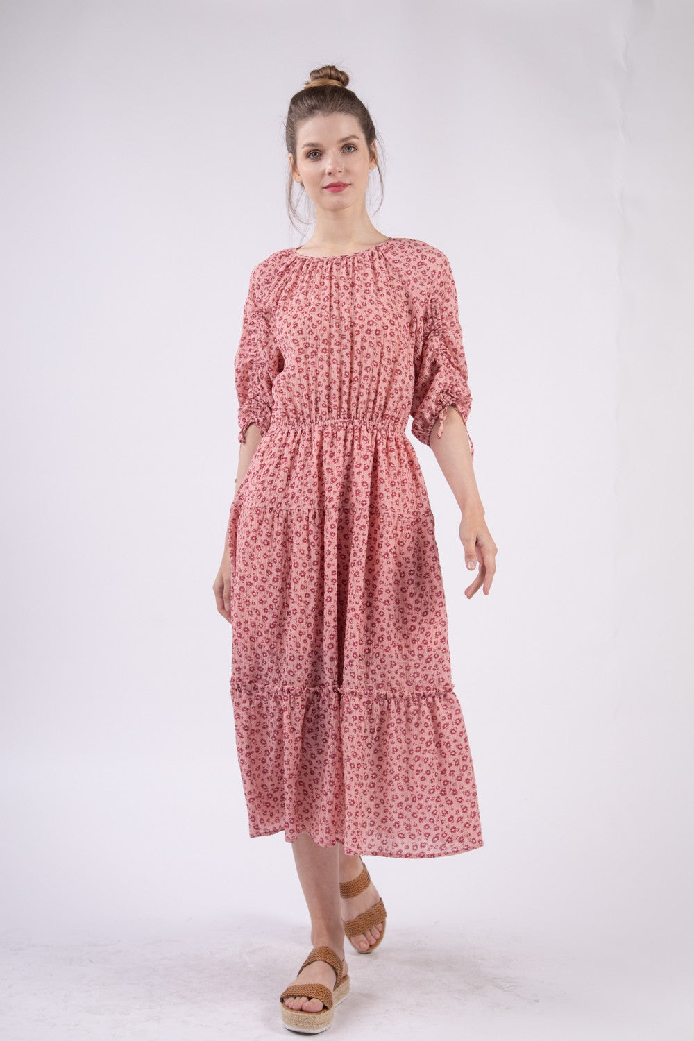 A woman wearing the VERY J Floral Round Neck Tiered Midi Dress and sandals poses gracefully against a plain white background.