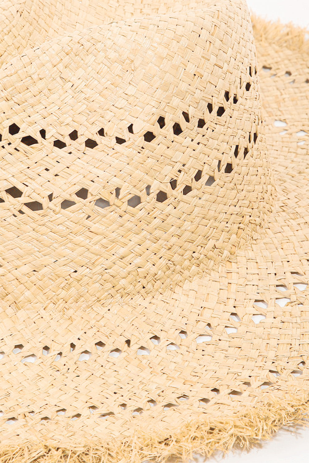 The Fame Openwork Raw Hem Weave Hat, with its wide brim and natural straw material featuring intricate openwork woven patterns, lies flat on a white background, making it the perfect chic summer accessory.