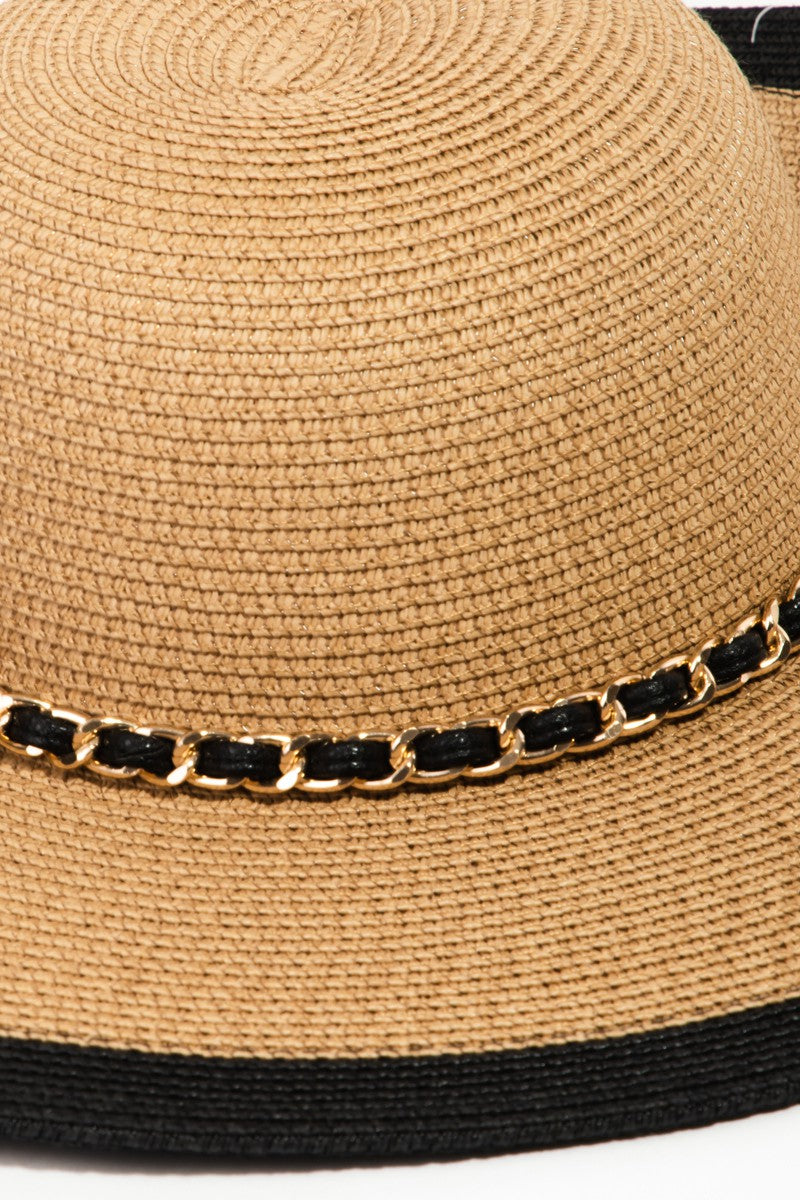 The Fame Chain Black Trim Straw Hat showcases a chic chain detail around its base, providing both elegance and sun protection with its wide brim.