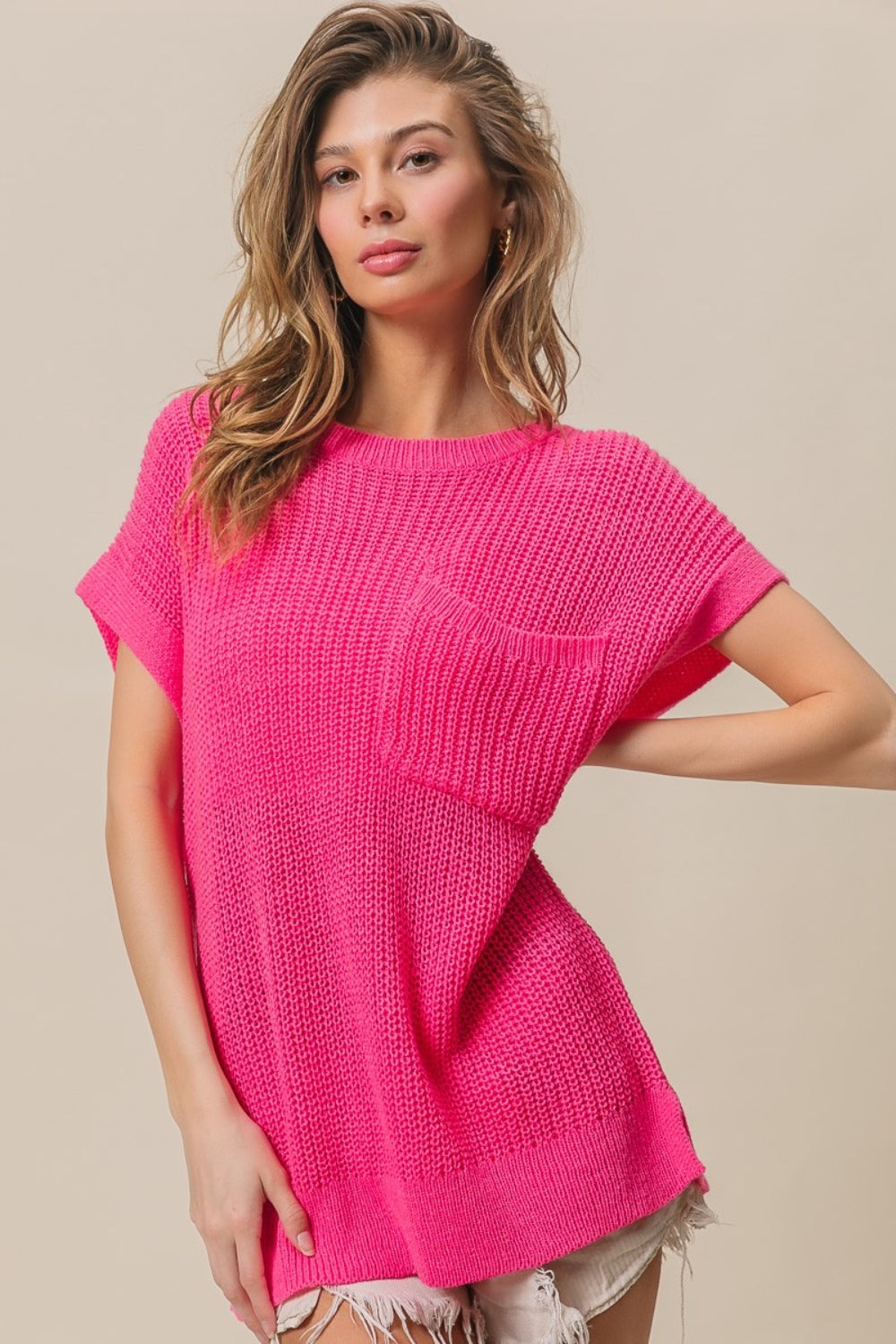 A woman wearing the BiBi Patch Pocket Short Sleeve Sweater, a cozy knit in pink.