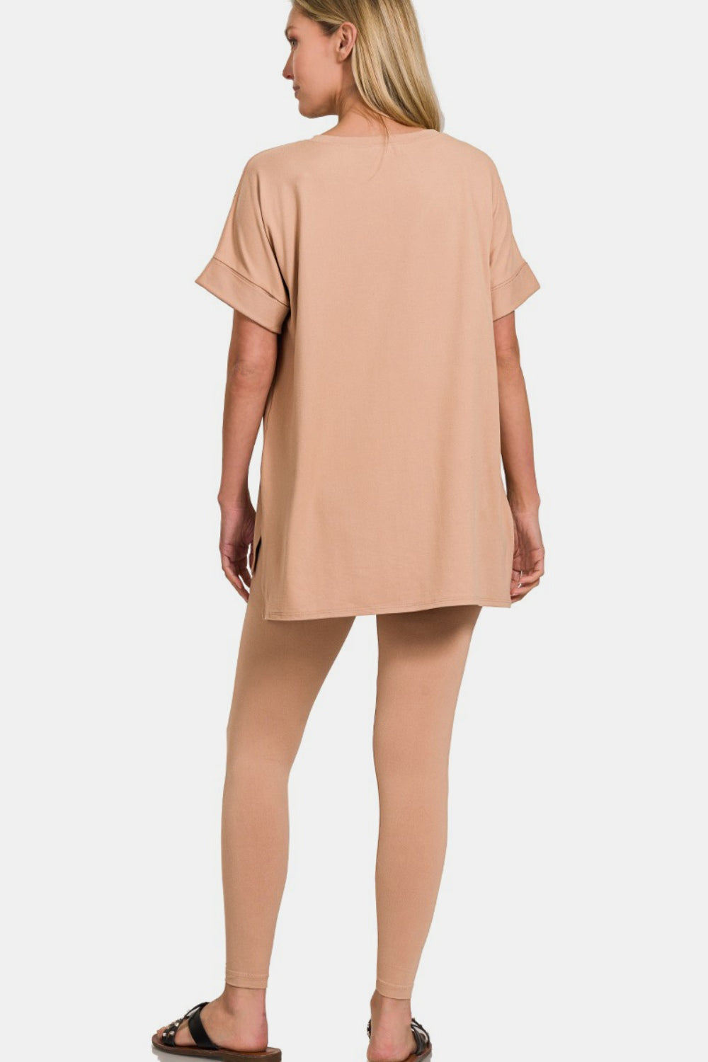 A person wearing the Zenana Full Size V-Neck Rolled Short Sleeve T-Shirt and Leggings Lounge Set in classic beige stands against a plain white background, exuding both comfort and style.