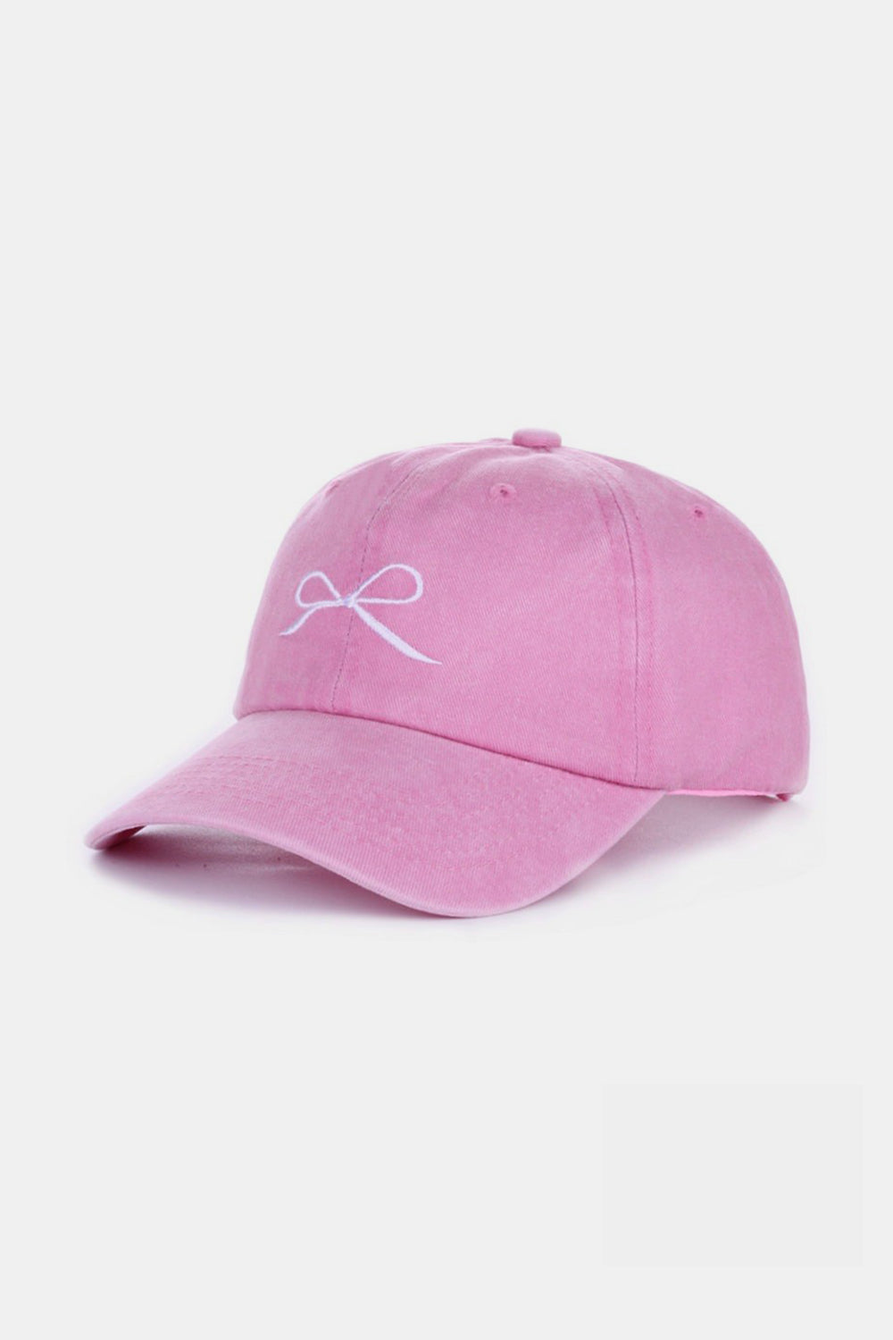 The Zenana Bow Embroidered Washed Cotton Cap features a pink design with a stylish white bow on the front, set against a plain, light background. This chic accessory seamlessly combines elegance and sportiness.