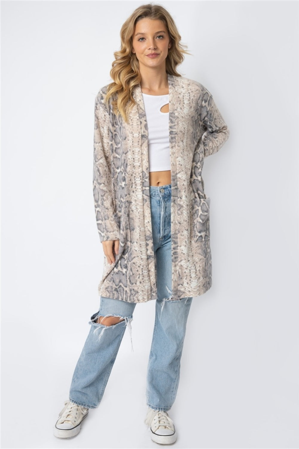 Person wearing a Cherish Apparel Animal Print Flannel Open Front Longline Cardigan with a snake motif, white top, and ripped jeans.