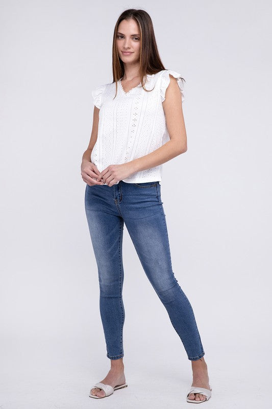 A person wearing a white Ruffle Sleeve V Neck Top and blue jeans, posing against a plain background.