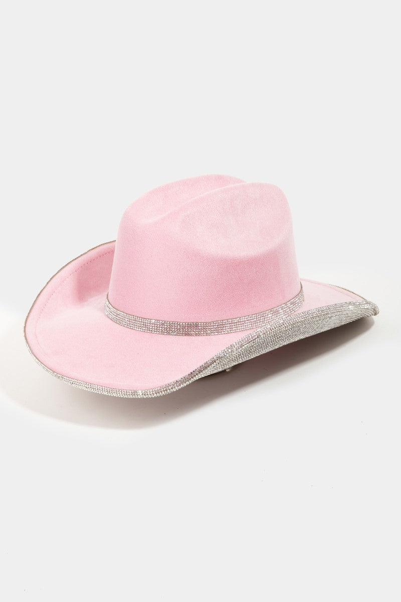 A woman with blond hair is wearing the Fame Pave Rhinestone Trim Faux Suede Hat in pink and a black top, looking at the camera against a plain white background.