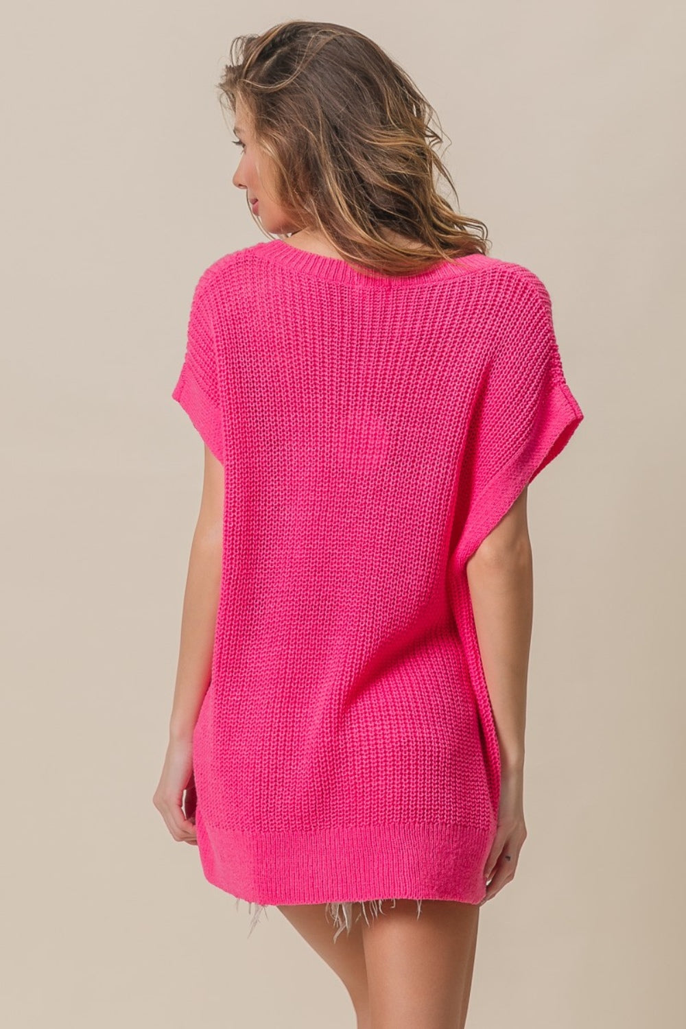 A woman wearing the BiBi Patch Pocket Short Sleeve Sweater, a cozy knit in pink.