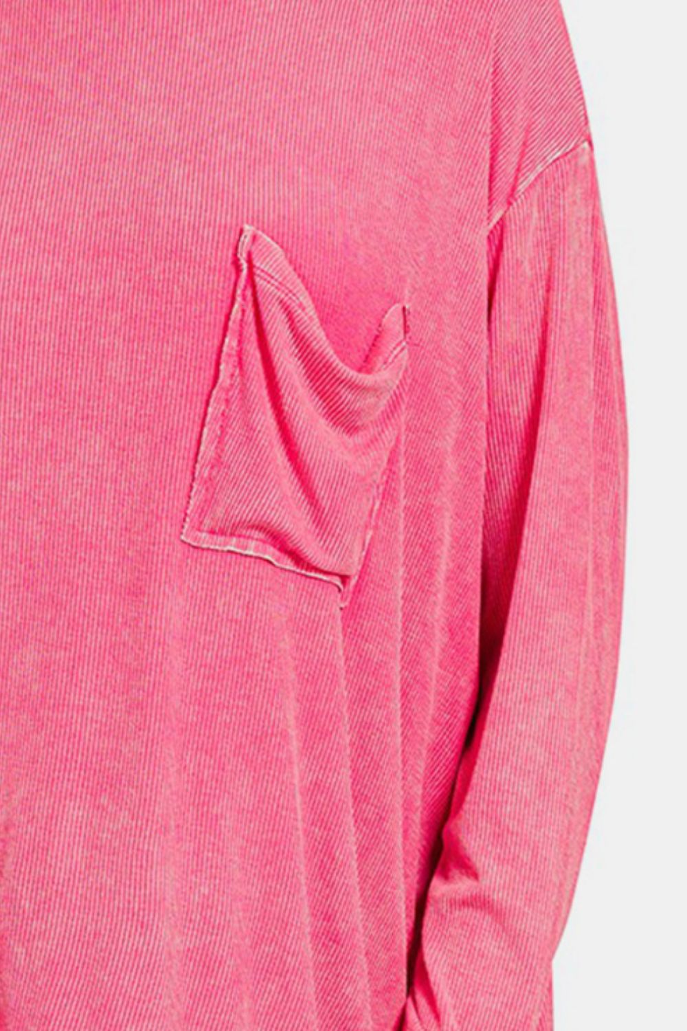 A person wearing the Zenana Round Neck Long Sleeve T-Shirt, known for its comfortable and stylish loose fit, complete with a front pocket in pink, paired with blue jeans effortlessly embodies a versatile staple.