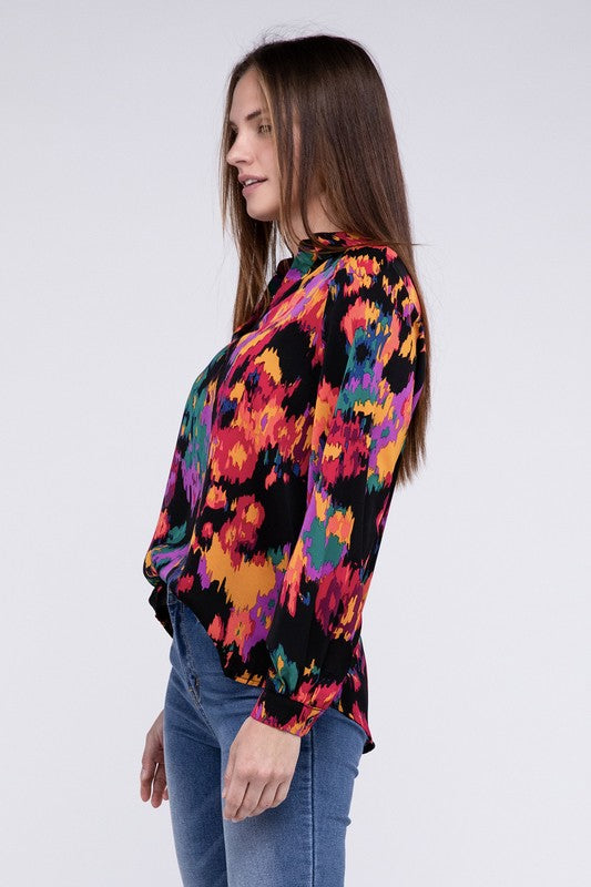 A person dressed in a vibrant Floral Raglan Sleeve Blouse featuring a V-neck stands against a plain backdrop, paired with jeans.