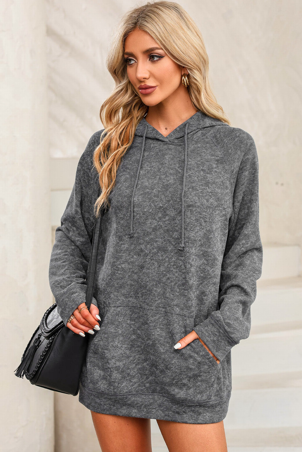 A person with blonde hair is standing with their back to the camera, wearing a Gray Mineral Wash Kangaroo Pocket Drawstring Pullover Hoodie.