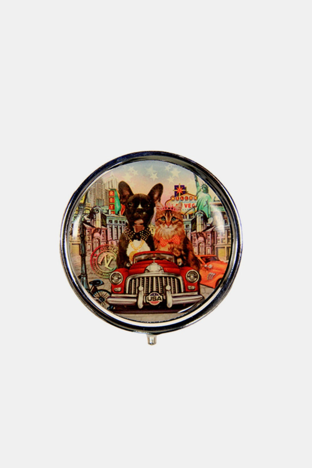 The Nicole Lee USA Print Metallic Circular Large Pill Case is a round pill case adorned with an illustration of a dog and cat driving an old-fashioned car, set against a backdrop of colorful city landmarks and signs. It's perfect for on-the-go medication management.