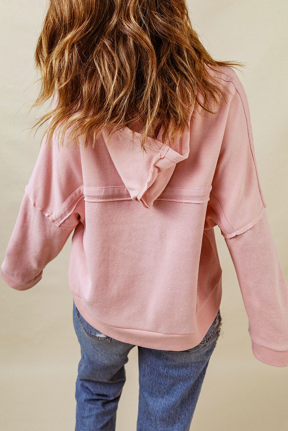 Person with wavy hair wearing a Pink Casual Button Solid Patchwork Trim Hoodie and blue jeans, photographed from the back against a plain background, showcasing fall and winter comfortableness.