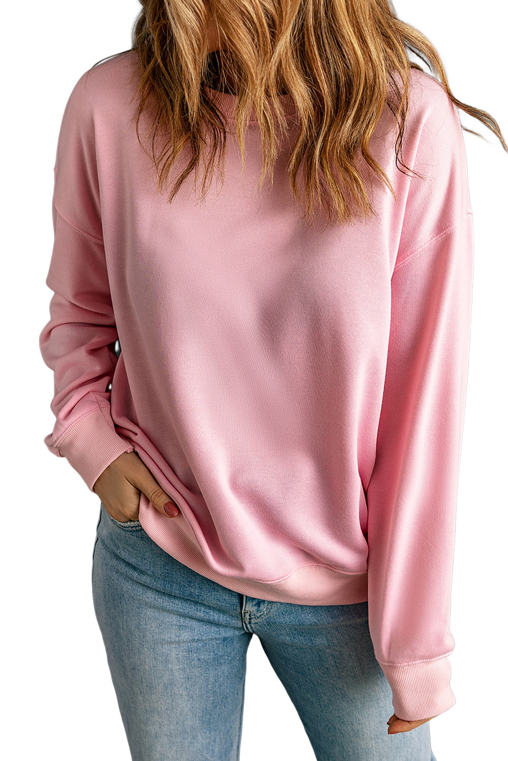 Individual with wavy brown hair wearing a Pink Plain Crew Neck Pullover Sweatshirt and blue jeans, standing with their back to the camera.