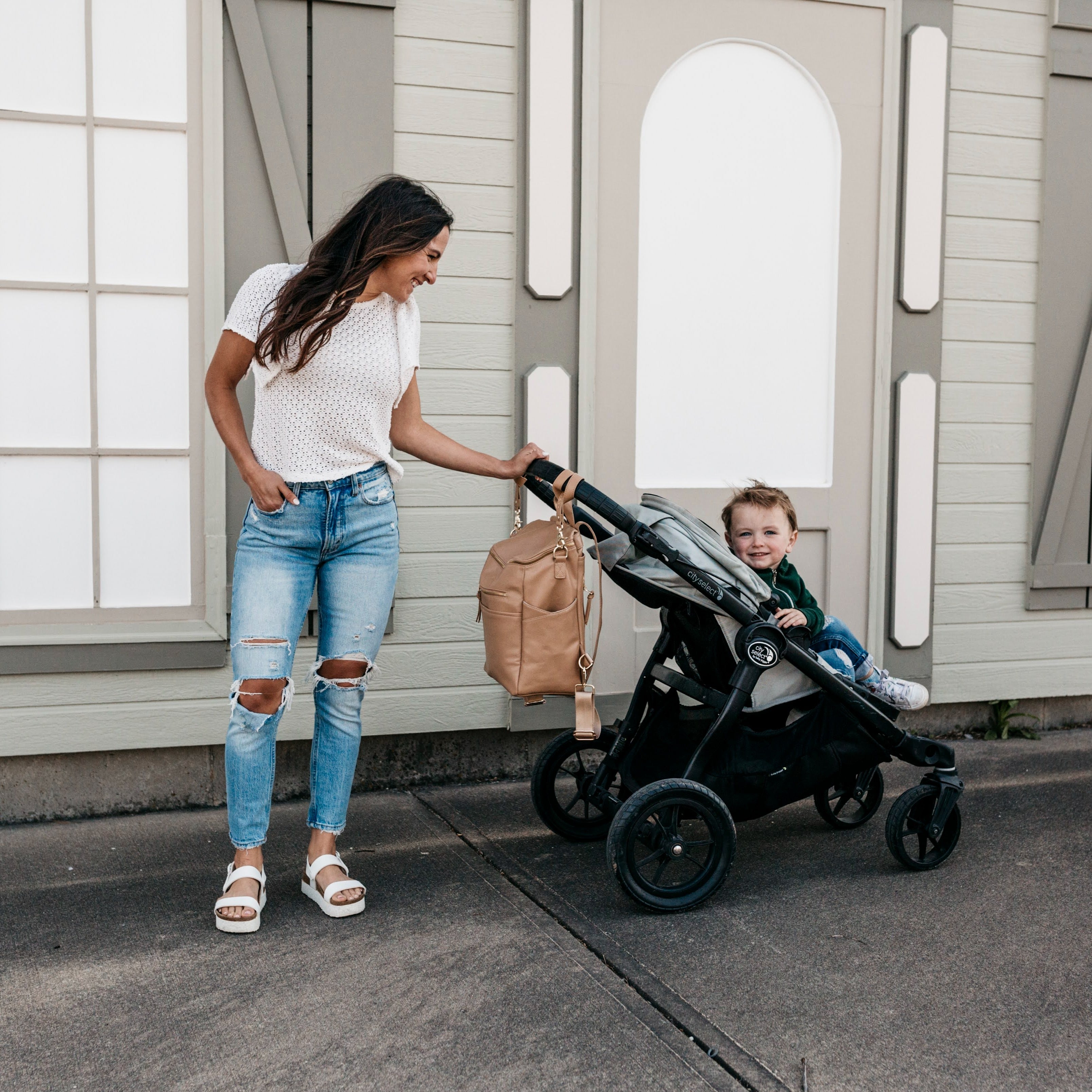 Eight high-quality Stroller Straps in various shades, including brown, beige, cream, and black, are displayed in a row with metal clasps at the bottom.