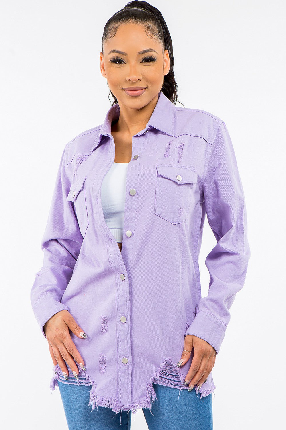 A person wearing an American Bazi Frayed Hem Distressed Denim Jacket over a light purple button-up shirt with a vintage look, paired with distressed denim jeans, standing against a plain background.