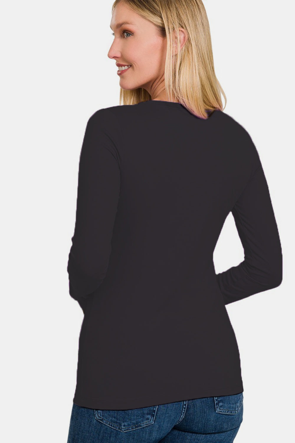 A woman in a sleek black dress, echoing the refined elegance of the Zenana Full Size Brushed Microfiber Long Sleeve Round Neck T-Shirt.