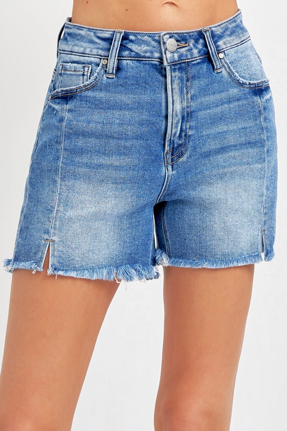 Close-up of a person wearing RISEN Front Slit Raw Hem Denim Shorts.