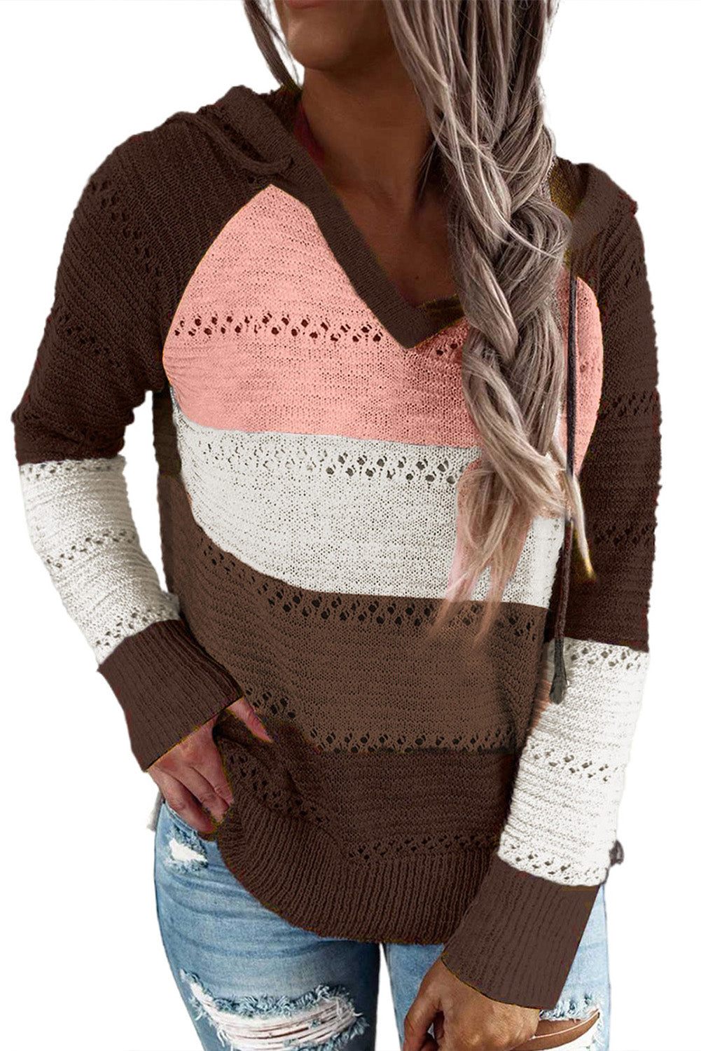 A person stands with their back to the camera, adjusting the hood of a Brown Beach Bonfire Knitted Hoodie featuring dark brown, pink, white, and light brown stripes. Perfect for a casual style, they are wearing distressed blue jeans and showcasing the laid-back vibe of lightweight hoodies.