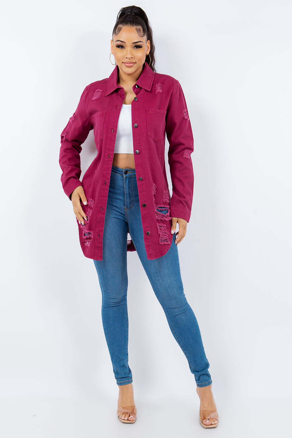 Person wearing an American Bazi Distressed Button-Up Long Sleeve Denim Jacket in pink over a white crop top and blue jeans, posing against a plain background.